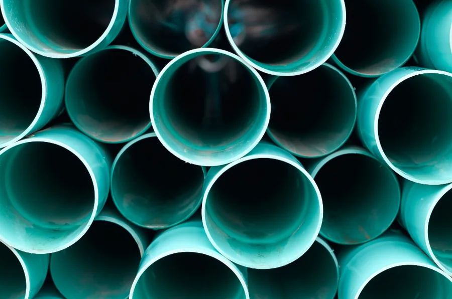 Stacked ends of teal PVC drainage pipes
